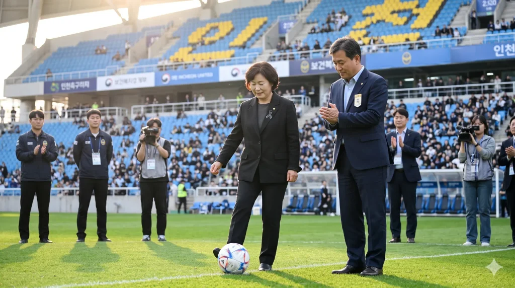 인천축구전용경기장 잔디 위에서 시축을 하는 유가족과 보건복지부 관계자가 관중석을 배경으로 서 있는 장면